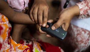 Lady helping baby use the vero fingerprint scanner