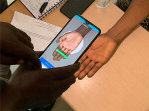 Simprints software in use on mobile device scanning someone's palm