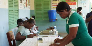 Community Health Worker updating paper records at a clinic