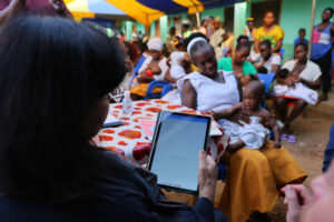 Simprints CEO Sania Nishtar uses the Simprints ID app to identify a baby at a health clinic in Ghana