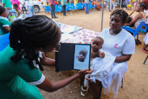 A child has his face scanned with the Simprints ID app to locate his medical record. 